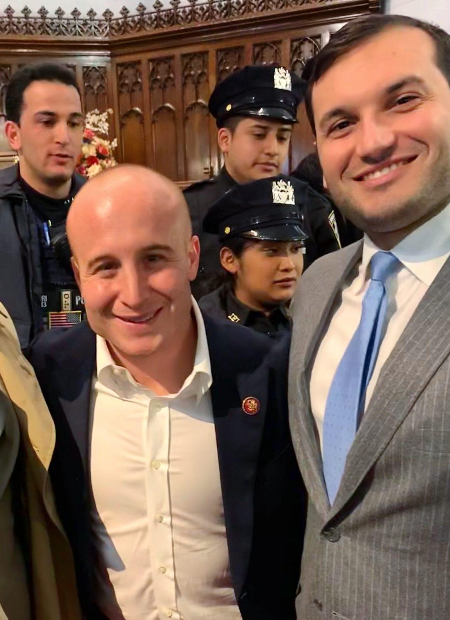 Three men in suits and ties smiling for a photo.