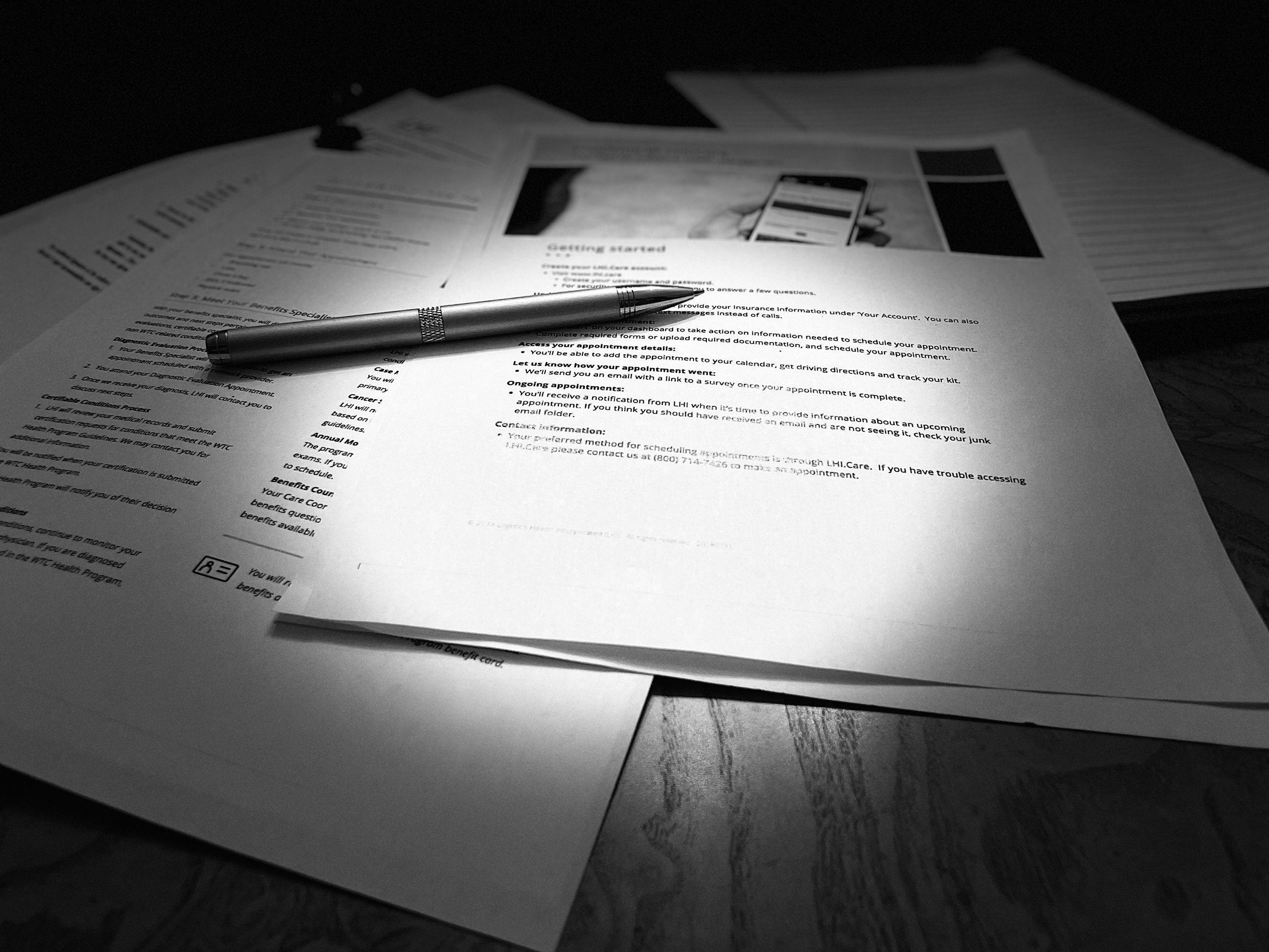 A grayscale image of documents and a pen