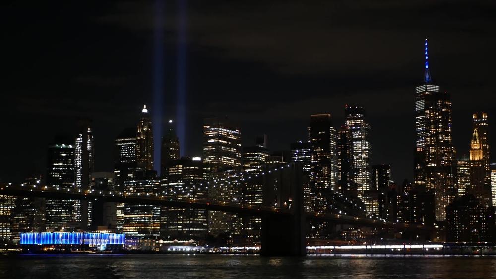New York City skyline at night with Tribute in Light beams above lower Manhattan